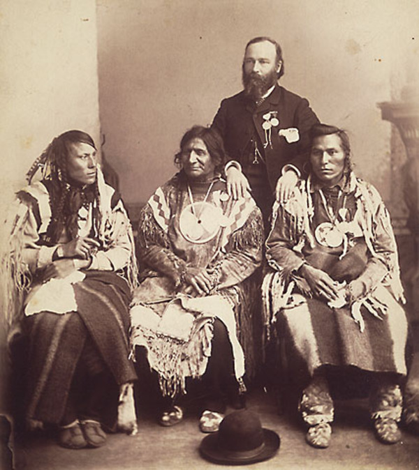 Titre original&nbsp;:  Chefs Pieds-Noirs et du Sang qui n'ont pas pris part à la Rébellion du Nord-Ouest de 1885 et qui ont été emmenés en Ontario par le gouvernement fédéral pour l'inauguration du monument à la mémoire de Brant. 
Sitting, left to right: One-Spot, PipeBearer of Crowfoot, Red Crow and North Axe. The interpreter is standing behind. 